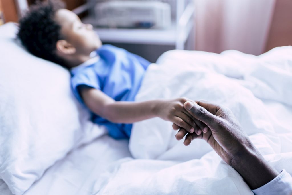 family holding hands, african american boy in hospital, pediatrics