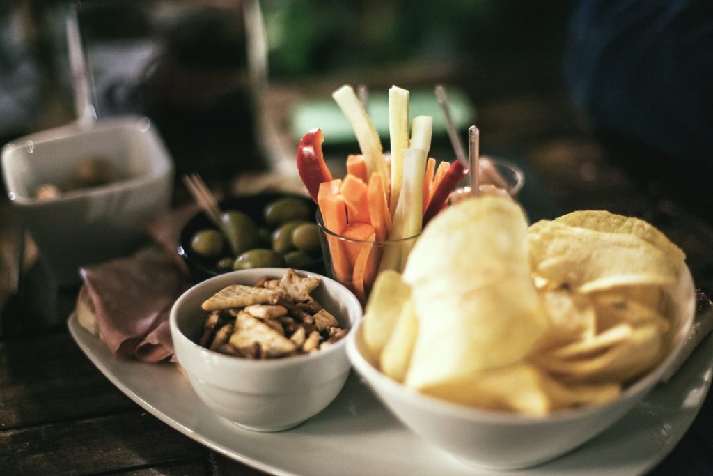 veggie snacks with chips and olives grapes crackers and veggie straws