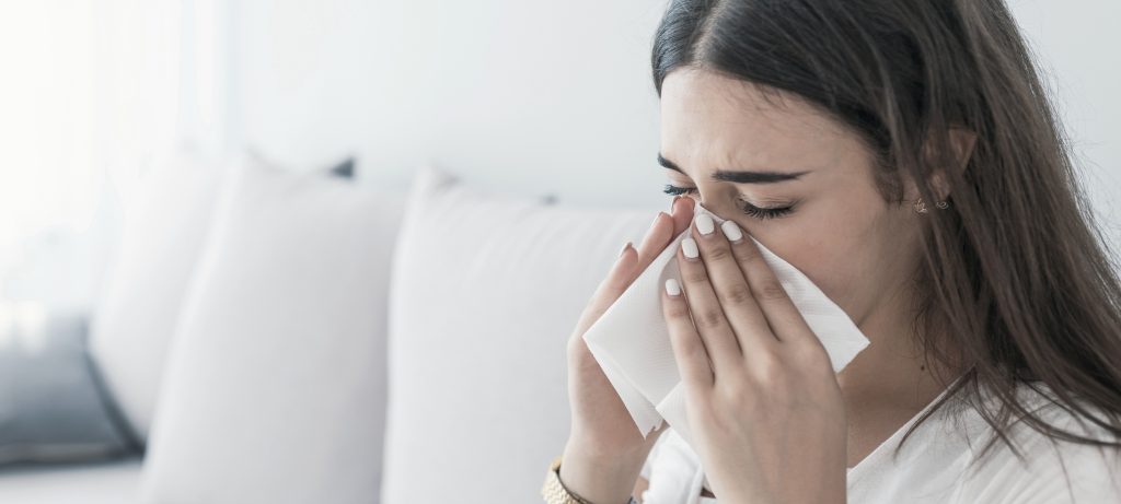 allergy relief is what this woman blowing her nose is wishing for