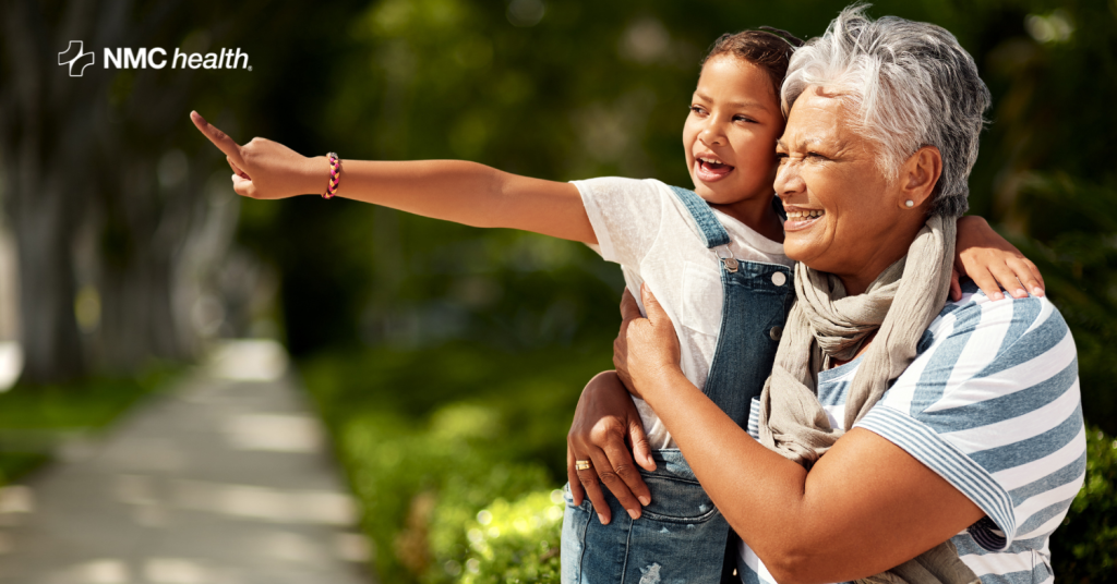 smiling grandma holding granddaughter