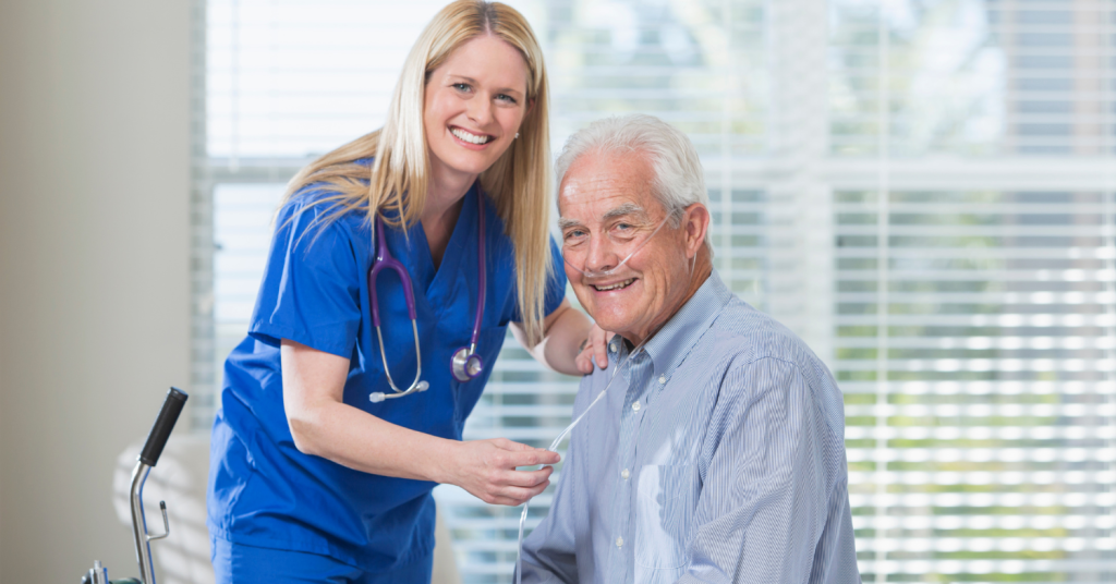 smiling blonde nurse checking the heart rate of an elderly male