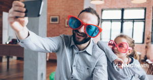 silly dad and child wearing big sunglasses taking selfie at home