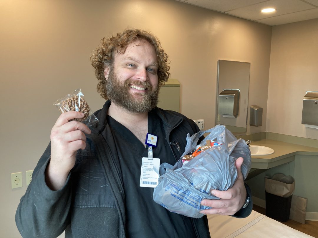 smiling man in hospital room holding candy