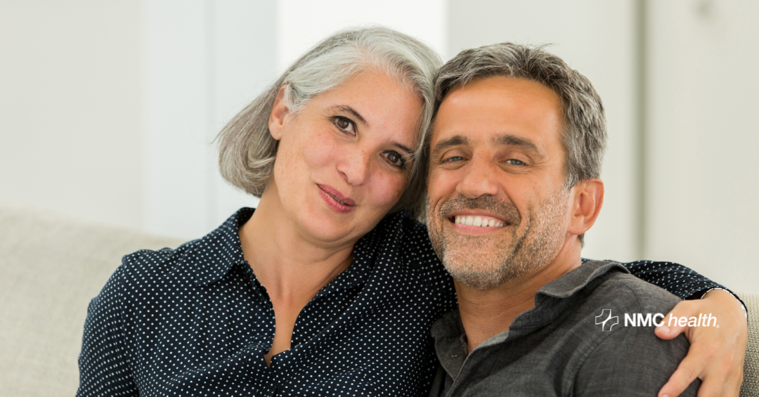 happy middle-aged male and female sitting together on couch