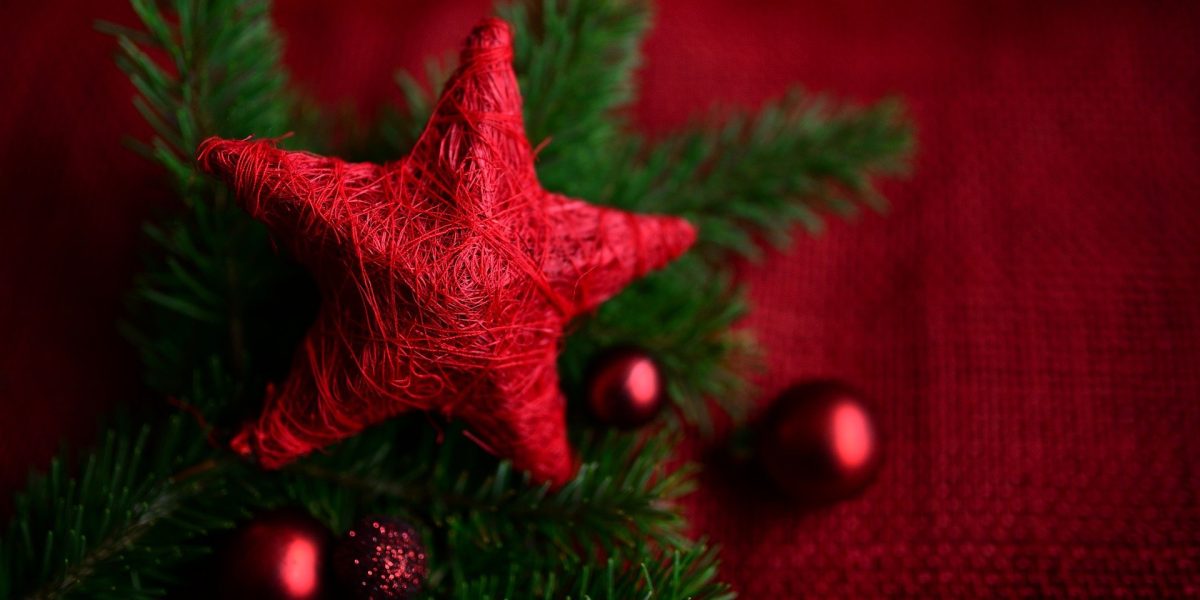 Red star tree topper with holiday decorations all around